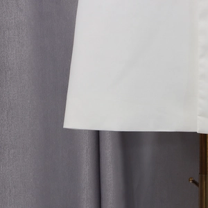 Détail de l'ourlet blanc épuré et du tissu tissé d'un trench-coat long élégant