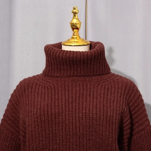 Détail du pull à col roulé bordeaux avec une texture en maille côtelée verticale
