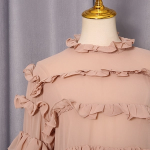 Detailed view of ruffle layers and standing collar on this lotus pink chiffon blouse