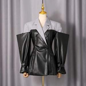 Detail of grey and black patchwork suit jacket featuring wide cuffs and leather texture