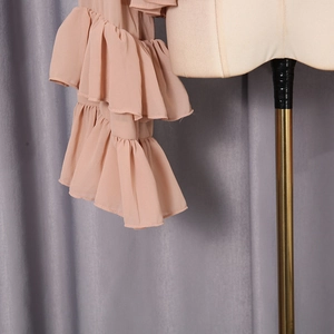 Detailed view of layered ruffles on the sleeve of a pink loose chiffon blouse for women