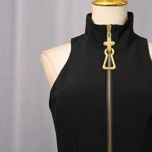 Detailed view of a black dress featuring a vintage gold cross-relief metal zipper