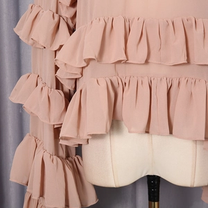 Detail view of multi-layer ruffles on apricot chiffon blouse with elegant texture