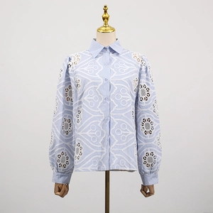 Detail of hollow-out white lace embroidery and fine blue stripes on long sleeve shirt