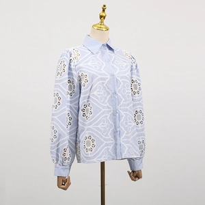 Detail of blue striped shirt with white floral hollow lace embroidery on the long sleeves