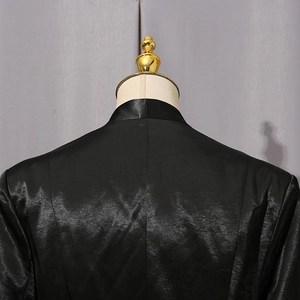 Détail du dos d'un blazer en satin noir avec un éclat soyeux sur un mannequin d'exposition