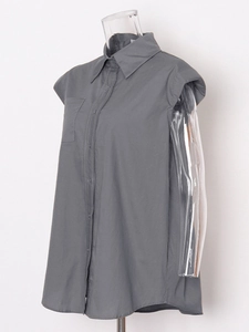 Minimalist dark grey sleeveless button-up shirt with collar and chest pocket on a mannequin