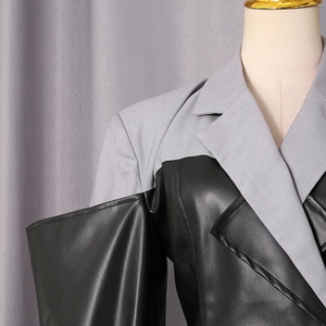 Detail of grey fabric and black PU leather patchwork on modern blazer lapel