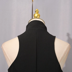 Detail of black dress featuring high neck design and vertical back seam craftsmanship