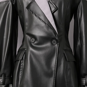 Detail of black double-breasted PU leather jacket featuring grey contrast lining and pockets