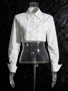 Camicia corta da donna bianca con pieghe intrecciate e maniche lunghe eleganti