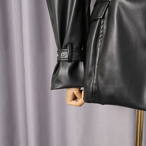 Detailed view of black PU leather jacket cuff with metal eyelets and adjustable strap