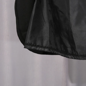 Detailed macro view of the black dress hemline with high-quality stitching and silk lining