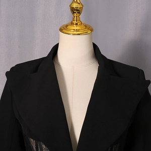 Detail of black blazer featuring large lapels and elegant lace patchwork at the waist