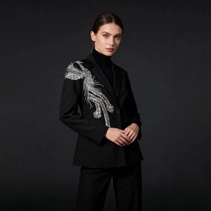 Détail de blazer noir élégant avec broderie de plumes argentées sur l'épaule droite