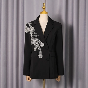 Détail de la broderie phénix argentée sur le blazer noir cintré à double boutonnage