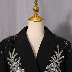 Detail view of black blazer featuring silver wheat embroidery and white pearl accents