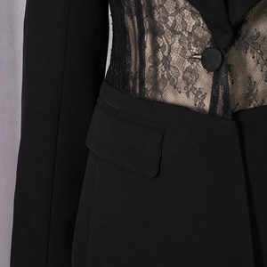 Detailed view of the sheer floral lace panel and fabric-covered button on a black blazer