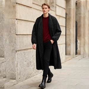 Outdoor street style shot of a long black quilted coat with classic diamond patterns
