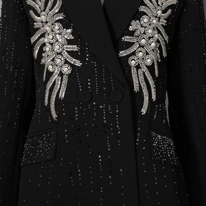 Close-up of luxury hand-beaded pearls and rhinestones on black blazer lapel and fabric