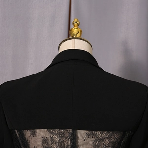 Detail of elegant black blazer featuring intricate lace patchwork on the sheer back panel