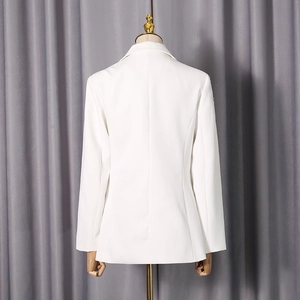 Vue arrière d'un blazer blanc cintré montrant des épaules structurées et une coupe élégante