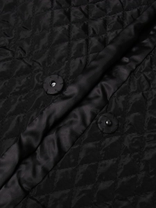 Close-up of black diamond quilted fabric with matching fabric-covered snap buttons