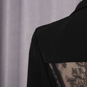 Detailed close-up of intricate black lace back stitching on a slim-fit blazer for women
