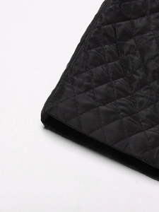 Detail of black diamond-quilted fabric texture on thick cotton winter coat for women