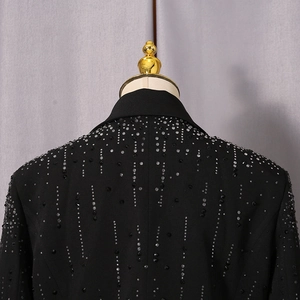 Detail of a black blazer featuring vertical silver rhinestones on the shoulder and back