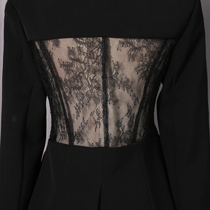 Detail of sheer floral lace patchwork on the back of a black slim-fit blazer jacket