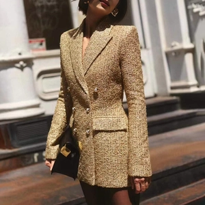 Detail of tweed blazer featuring golden metallic texture and pearl double-breasted buttons