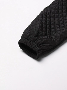 Close-up of black quilted jacket cuff showing diamond patterns and elastic windproof wrists