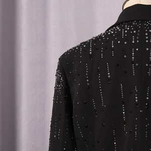 Detail of multi-color rhinestones on a structured black blazer with fringe effect