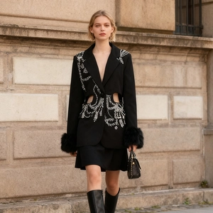 Détail d'un blazer noir avec broderies de perles et poignets en fausse fourrure chic