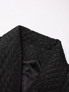 Detail of black diamond-quilted jacket featuring sleek satin lining and stand collar