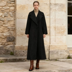 Chic long black quilted coat with wide lapels paired with beige turtleneck and boots