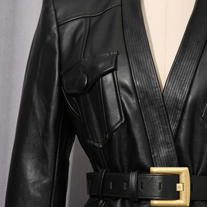 Close-up of black leather jacket with slim fit cut, V-neckline and gold buckle waist belt