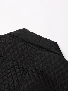 Detailed close-up showing the diamond quilted pattern on a black padded winter coat