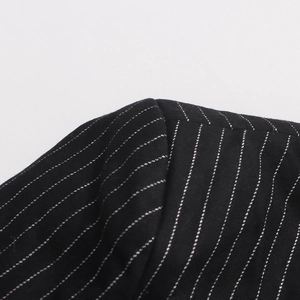 Macro shot of striped wool suit shoulder with refined stitching on black fabric