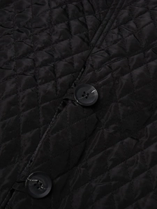Detailed close-up of black quilted fabric with diamond pattern and marble texture buttons