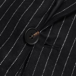 Close-up of fine pinstripe wool fabric with resin button detail on a black blazer