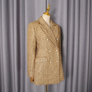 Detail of gold tweed blazer with white pearl buttons and double-breasted closure