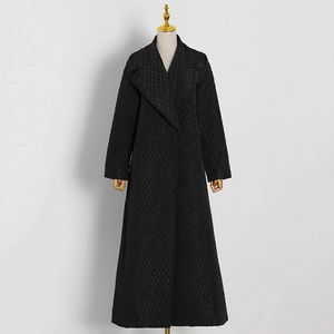 Detailed close-up of a black quilted long coat featuring a classic diamond pattern texture