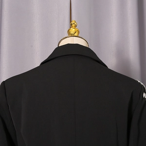 Détail du dos d'un blazer noir avec broderie de paillettes argentées sur l'épaule droite