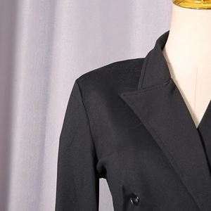 Detail shot of black fitted bodysuit showing notch lapel and tailored shoulder seams