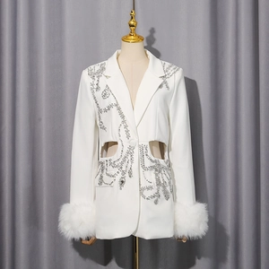 Détail de blazer blanc avec broderie en strass et poignets en plumes luxueuses