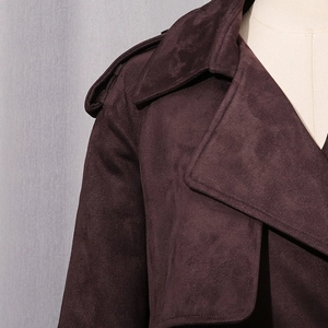 Detail of dark brown faux suede trench coat featuring classic epaulettes and lapel design