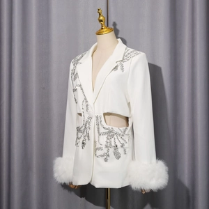 Vue détaillée d'un blazer blanc avec broderie en strass et poignets en fausse fourrure