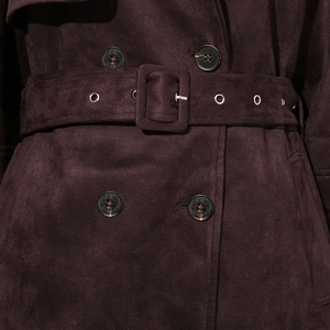 Detail of deep purple faux suede trench coat featuring double-breasted buttons and belted waist